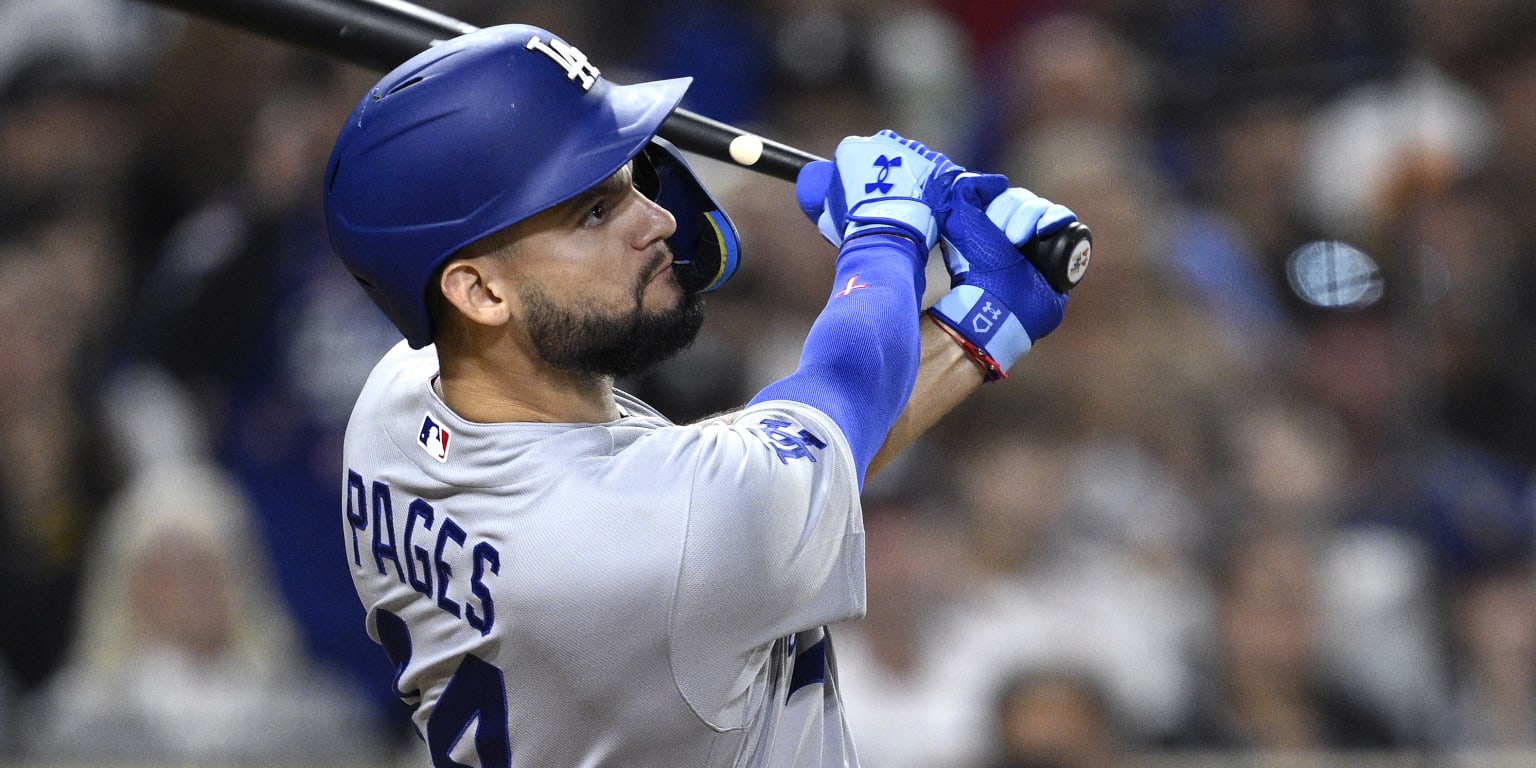 Andy Pages celebrating after hitting a walk-off RBI single against the Padres, with Dodgers teammates cheering in the background.