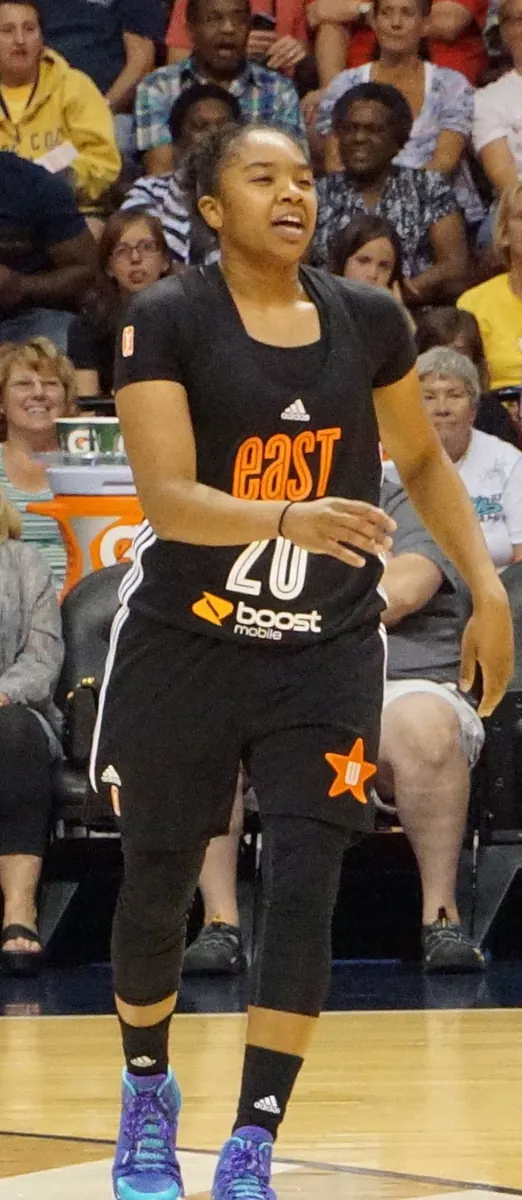 Minnesota Lynx player Olivia Miles drives to the basket during a WNBA game, with Indiana Fever player Sophie Cunningham observing.