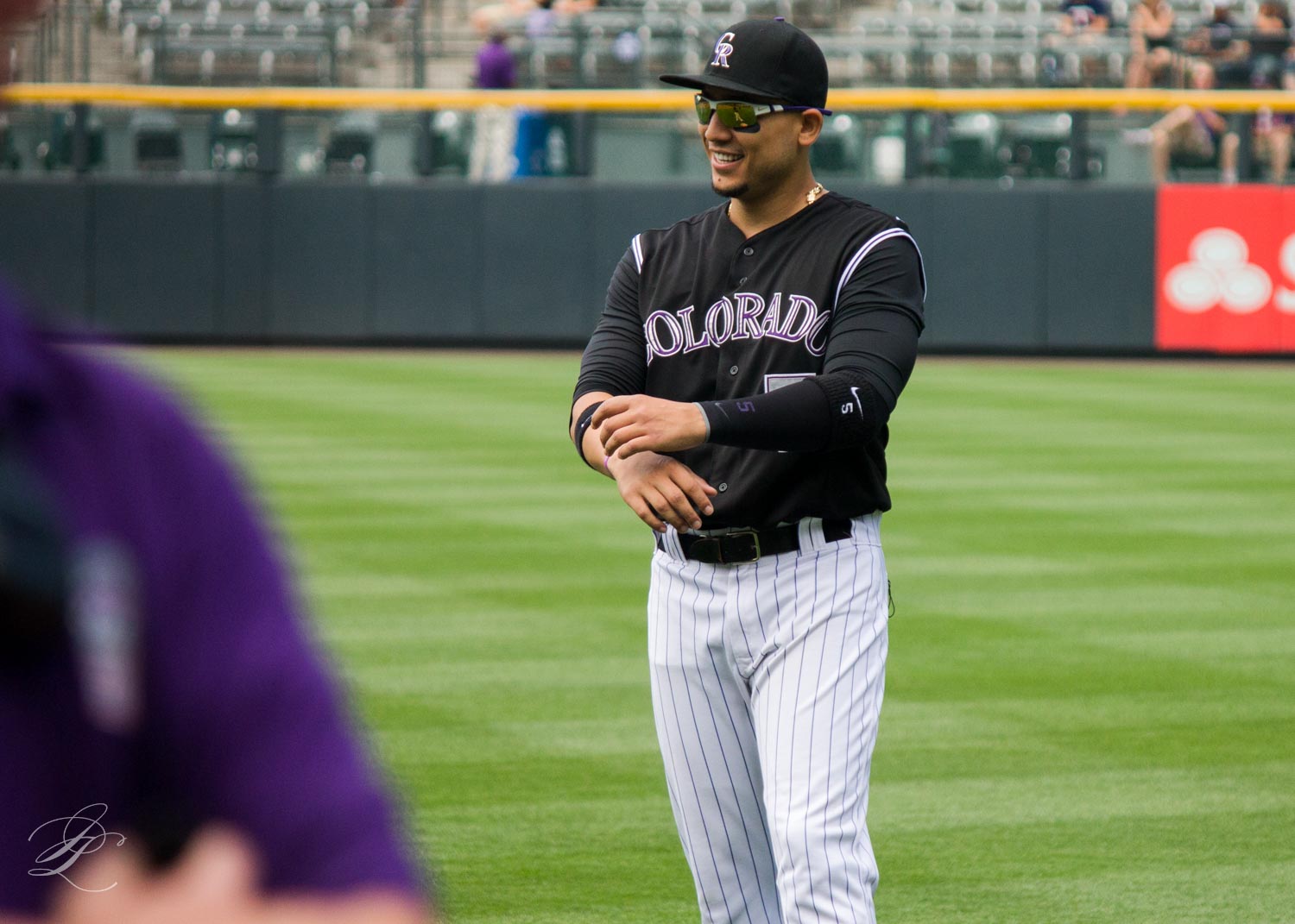 Colorado Rockies baseball player rounding the bases after a hit.