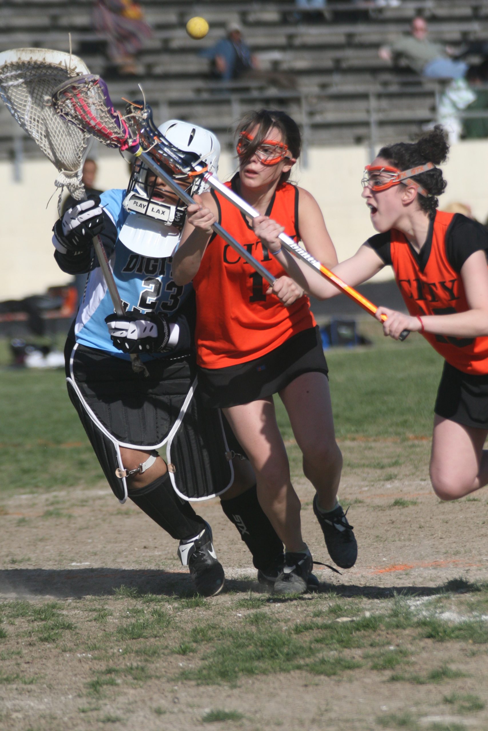Girls lacrosse players competing during a match at Centerville's Alumni Stadium.
