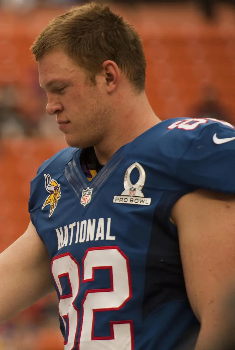 A football player holding the NFL MVP trophy, symbolizing the league's most valuable player award.