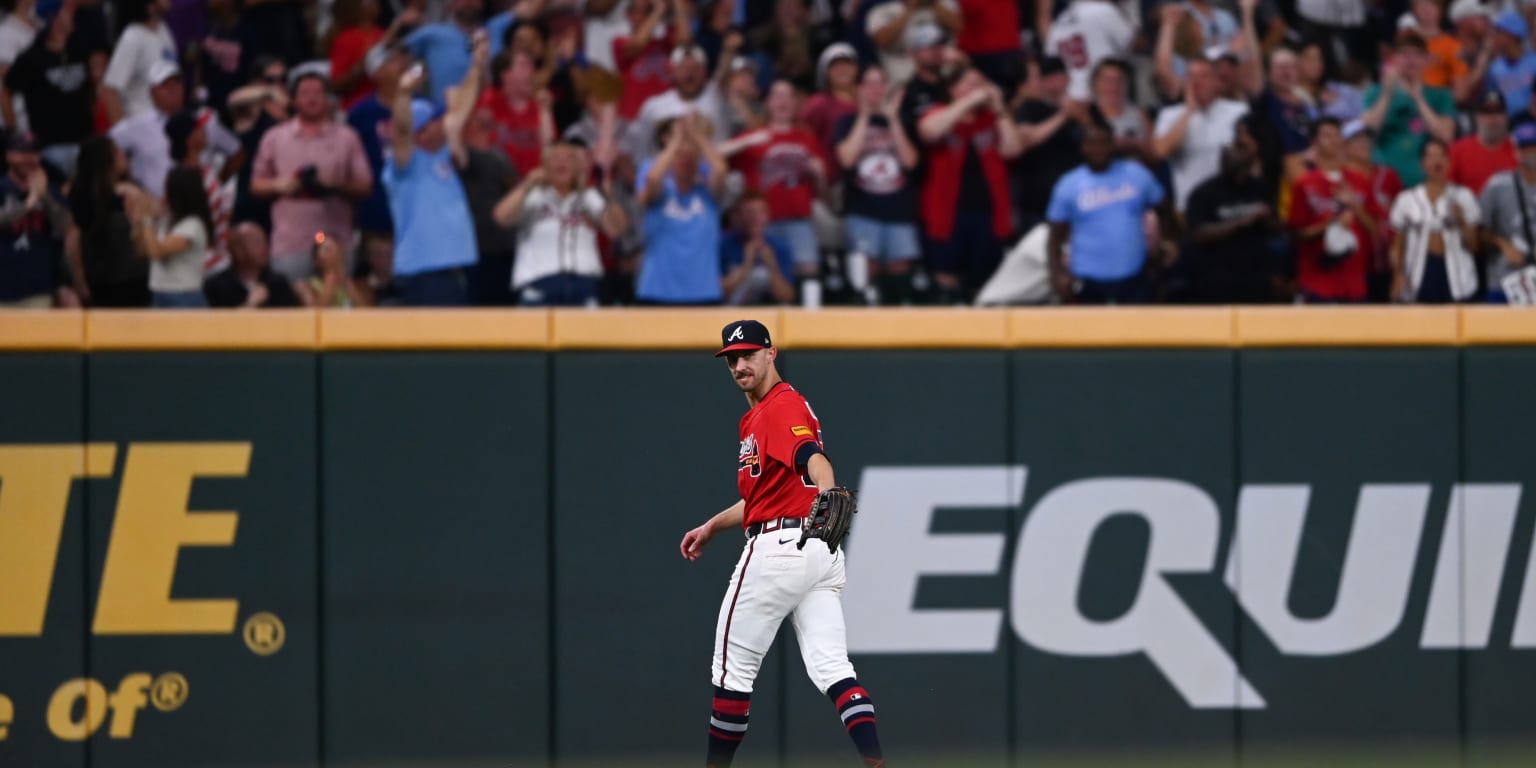 Atlanta Braves left fielder Eli White makes a strong throw towards home plate during a game.