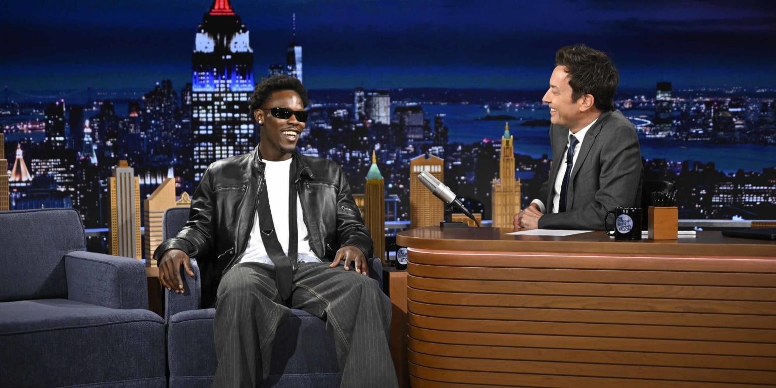 Jazz Chisholm Jr. sitting with Jimmy Fallon on The Tonight Show set.