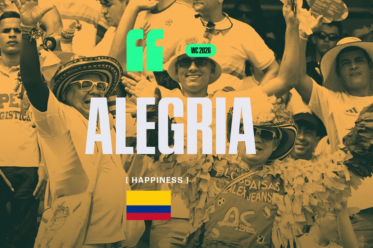 A vibrant crowd of Colombian football fans wearing yellow jerseys, cheering enthusiastically at a match.