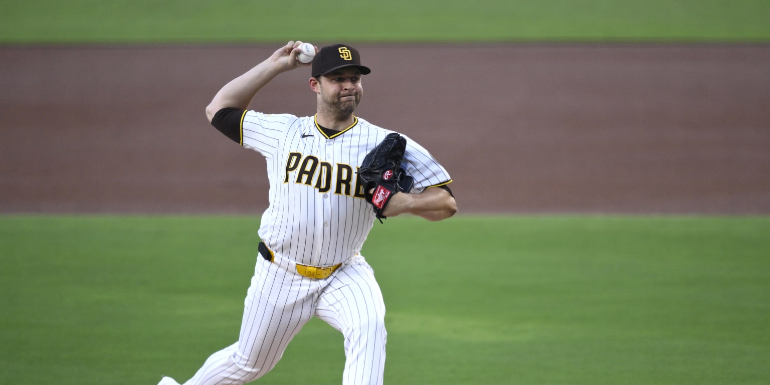 A baseball pitcher on the mound during a game, with a stadium crowd blurred in the background.