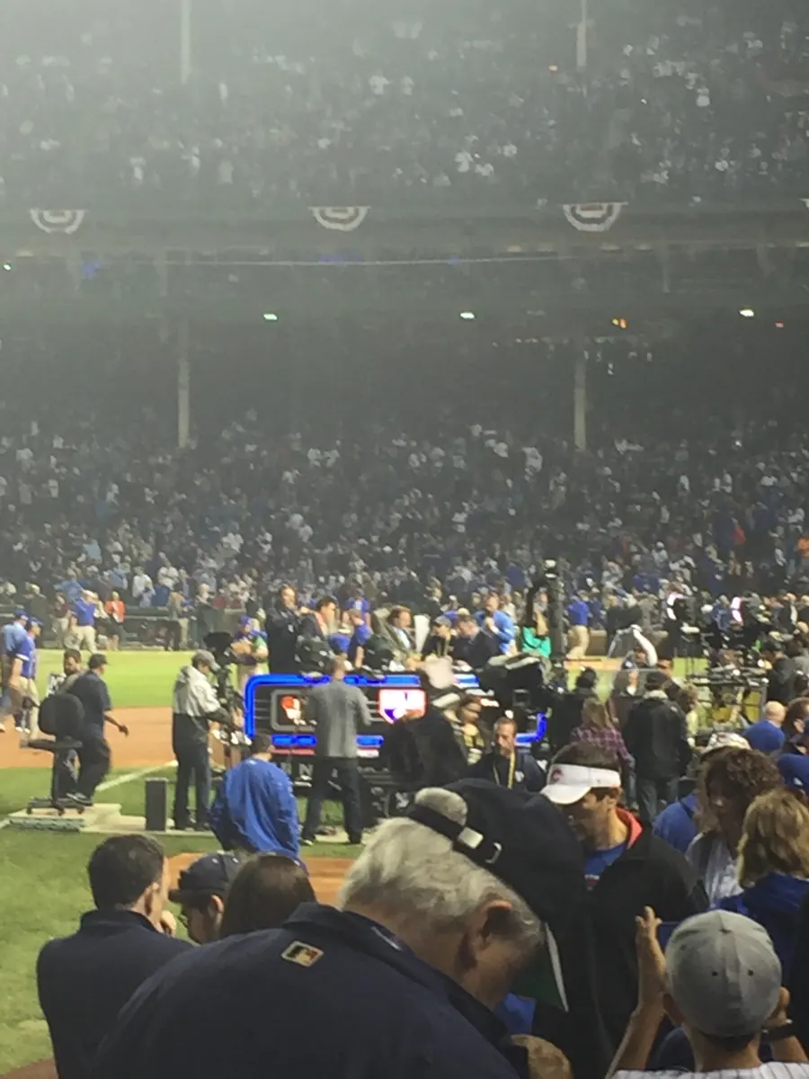 A baseball game is being played on a field under stadium lights.
