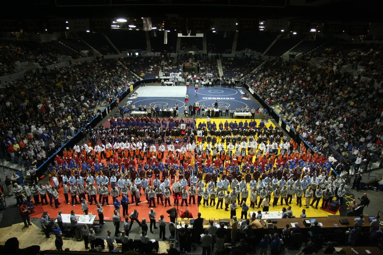 A dynamic photo capturing high school wrestlers in action during a match.
