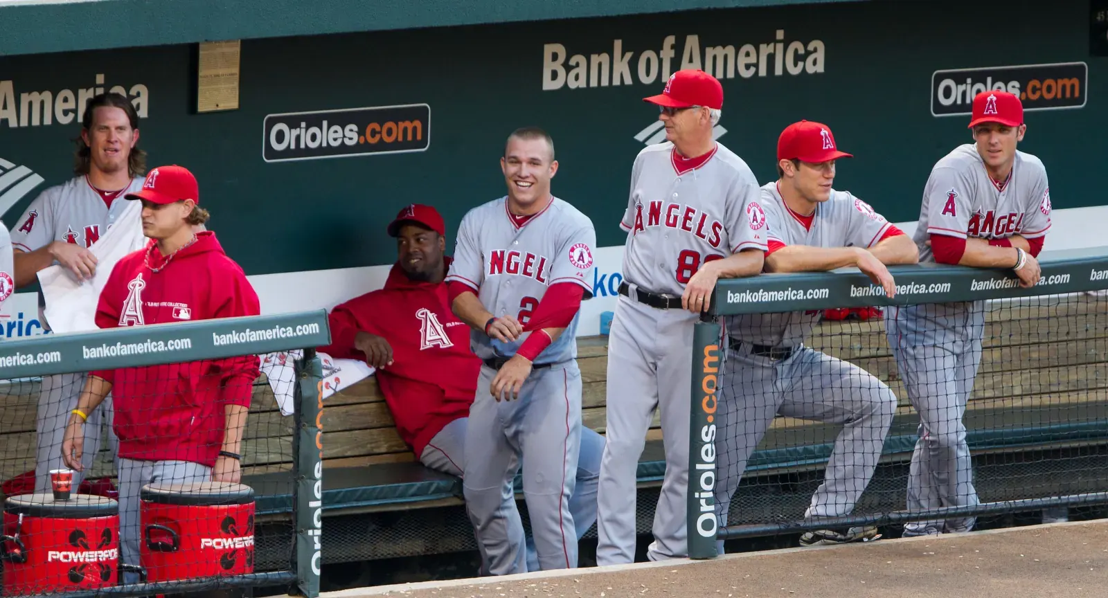 Baseball players and coaches in a dugout during a game.