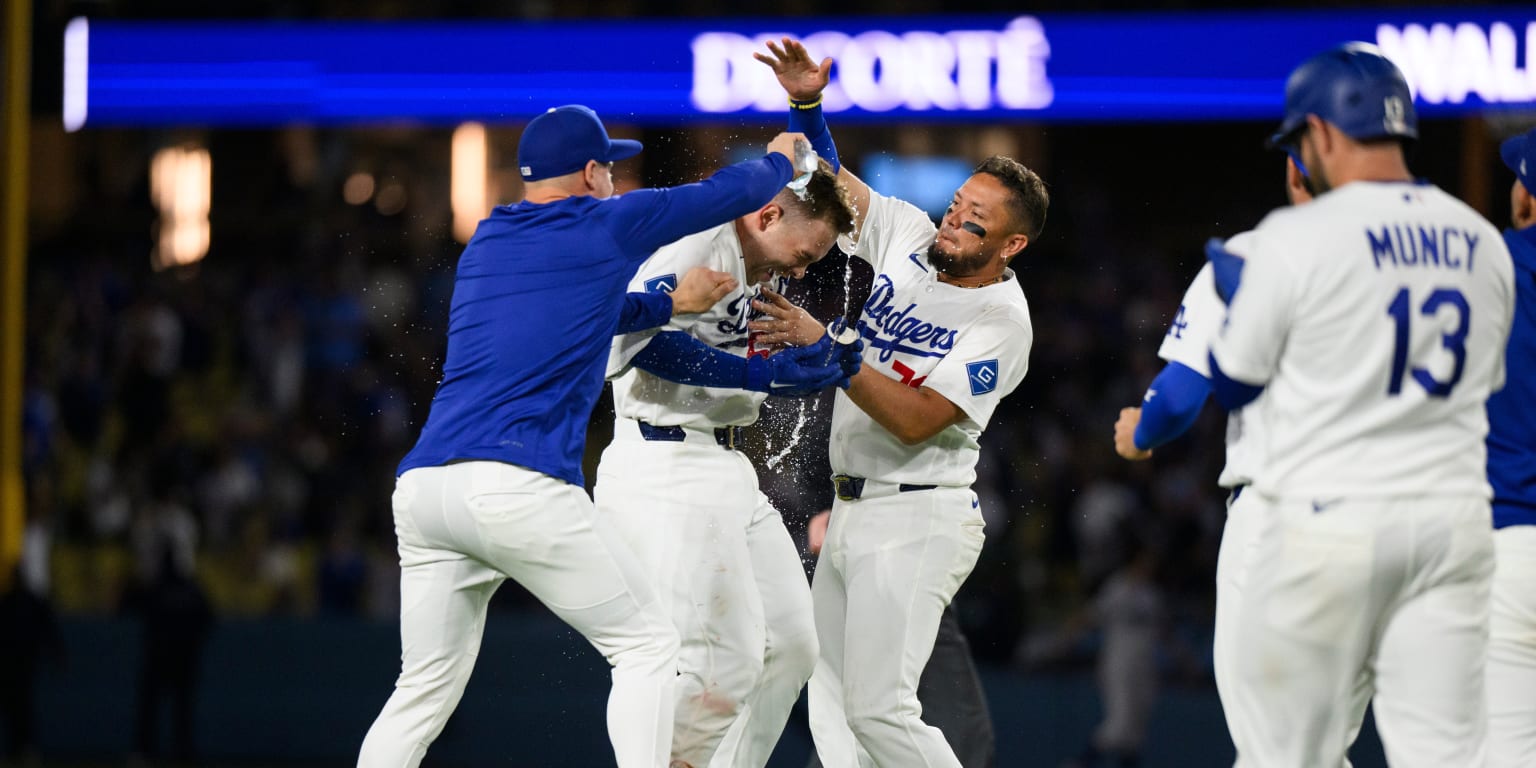 Los Angeles Dodgers players celebrating a walk-off hit in an extra-inning game.