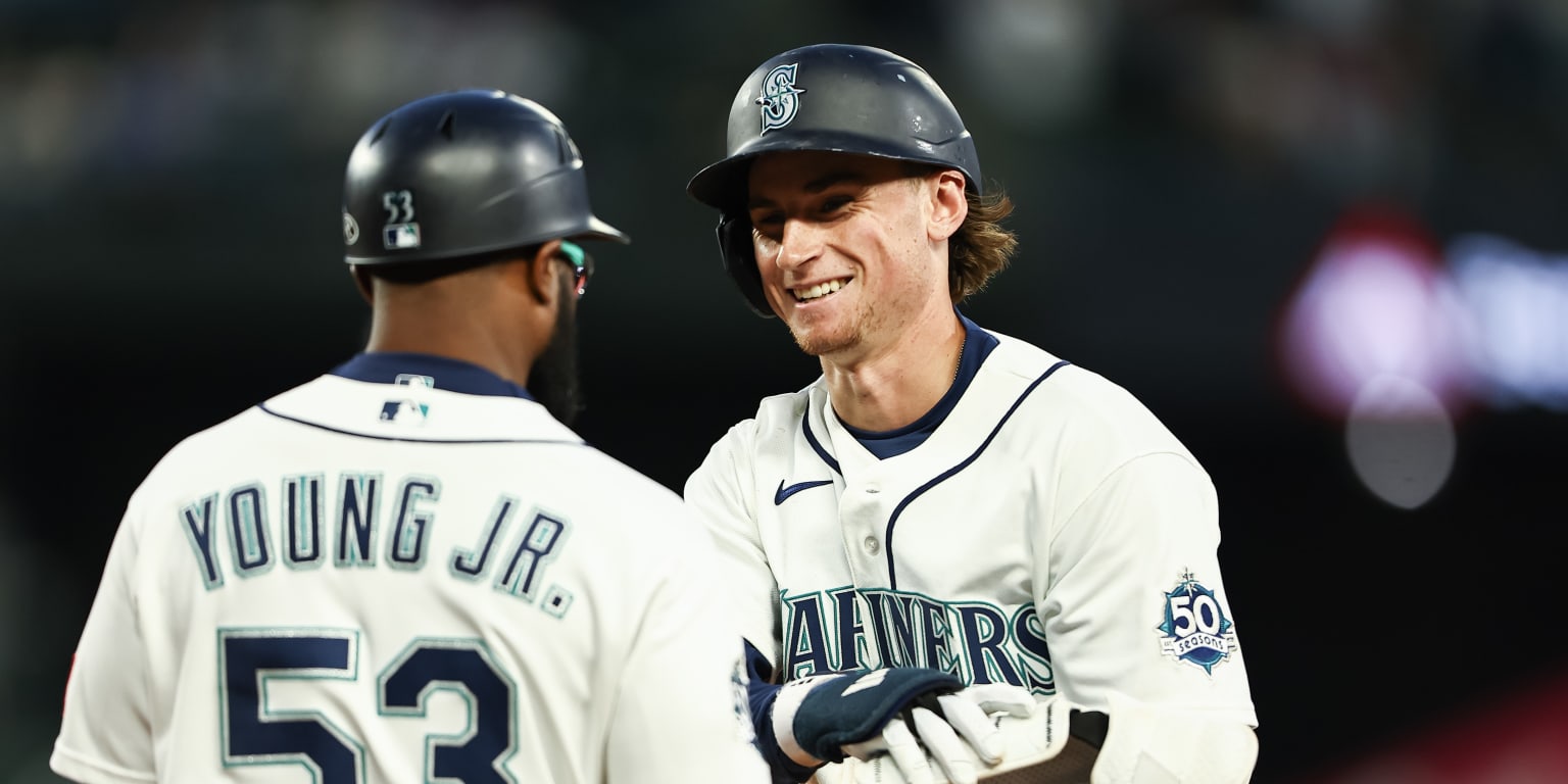 Seattle Mariners players celebrating on the field after a baseball game win.