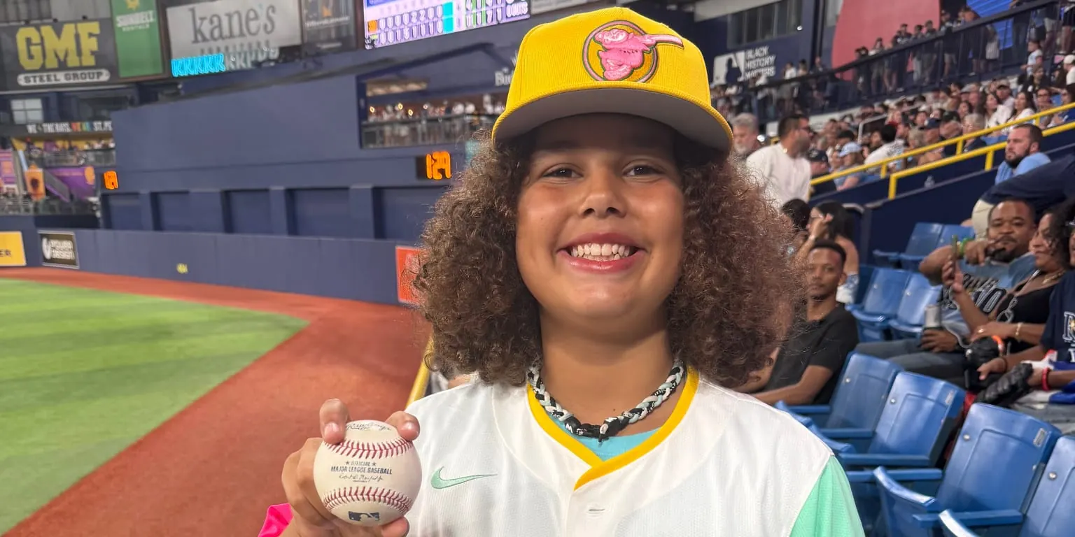 Fernando Tatis Jr. of the San Diego Padres fist bumps a 12-year-old fan in a Tatis City Connect jersey at Tropicana Field after the fan caught a home run ball